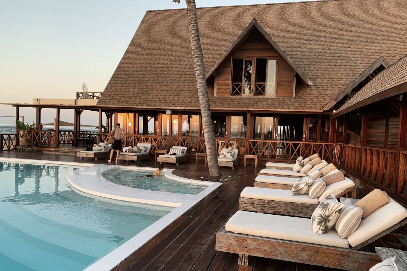 Sun loungers beside a safari lodge pool overlooking the bush